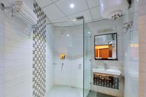 a bathroom with a glass shower and a sink at Galleu Hill Resort, Kufri Himalayan view resort in Cheog