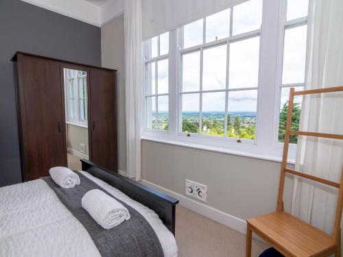 a bedroom with a bed and a large window at Pass the Keys High Spec 2 Bedroom Apartment with a View in Great Malvern