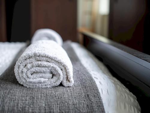 a towel is sitting on the edge of a bed at Pass the Keys High Spec 2 Bedroom Apartment with a View in Great Malvern
