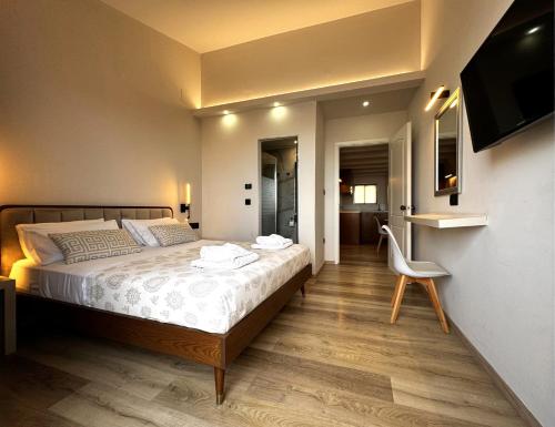 a bedroom with a bed and a chair and a television at Elina Hotel Apartments in Rethymno Town