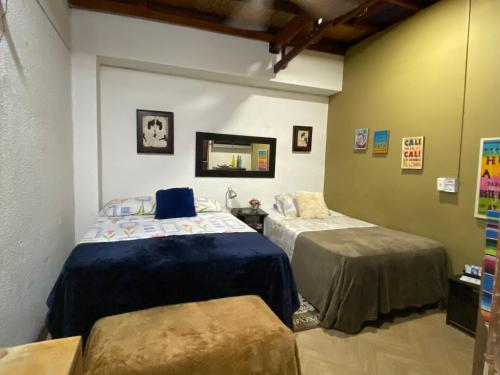 a bedroom with two beds and a mirror at Apartarstudio muy bien ubicado, cercano a todo!! in Cali