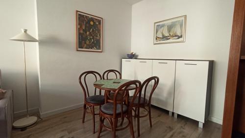 a dining room with a table and four chairs at Ustka Na Wydmie in Ustka