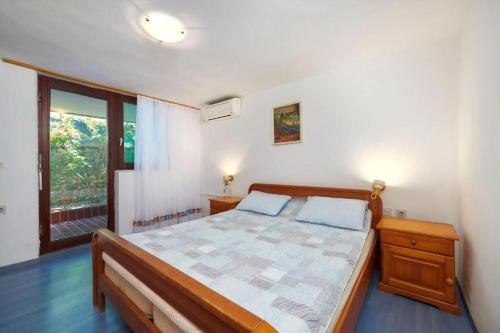 a bedroom with a bed and a large window at Apartments Davorka in Banjole