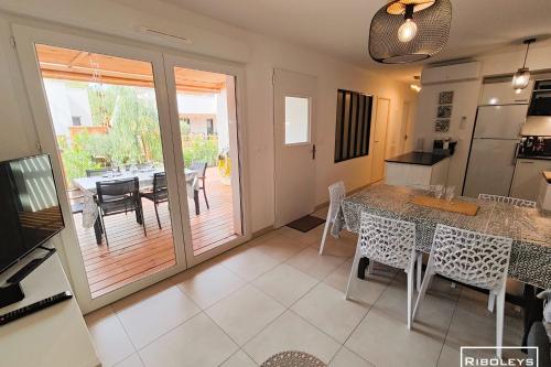 une cuisine et une salle à manger avec une table et des chaises dans l'établissement Villa T3 climatisée en résidence avec piscine, à Vias