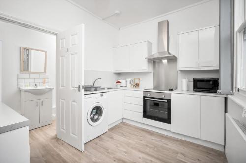 a kitchen with white cabinets and a washer and dryer at Perry Barr -1 Bed Canal Side Apartment - Top Rated - Netflix - Wifi - Parking - 1PB in Birmingham