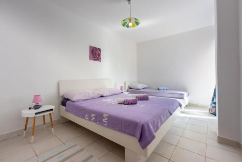 a bedroom with a large bed with purple sheets at Apartments Davor in Banjole