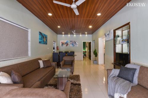 Una sala de estar con sofás y un ventilador de techo. en EKO STAY- Villa BLANCO, en Lonavala