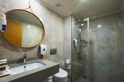 een badkamer met een douche, een wastafel en een spiegel bij Side Royal Style Hotel in Side
