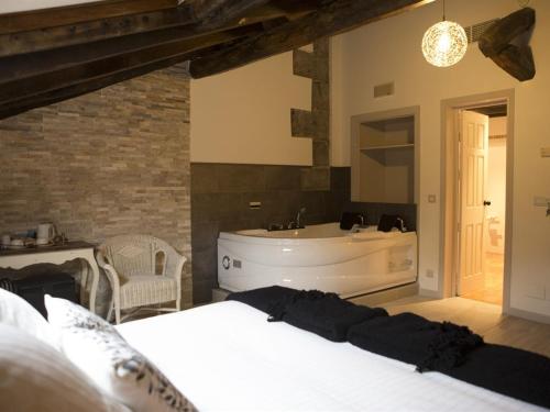 a bedroom with a bed and a bath tub at Akla Hotel Palacio Torre de Ruesga in Lastras