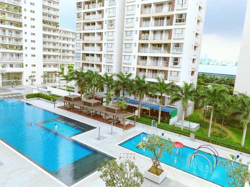 an image of a swimming pool in a building with palm trees at Scenic Valley With Free BreakFast, Free Massage, More Discount Supermarket in Ho Chi Minh City