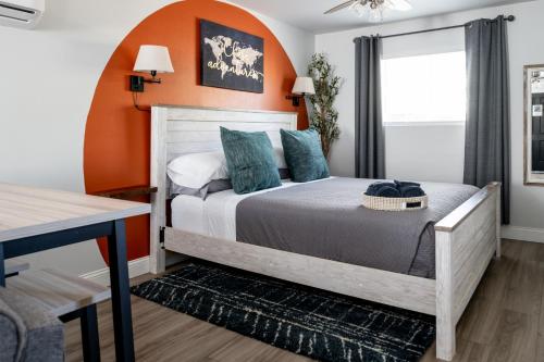 1 dormitorio con 1 cama con pared de color naranja en McKamy Cottage at Wrenwood Ranch, King Bed, en Johnson City