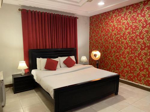 a bedroom with a bed with a red wall at Harvey's Islamabad in Islamabad