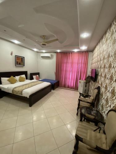 伊斯蘭堡的住宿－Harvey's Islamabad，一间卧室配有一张床、一张桌子和一把椅子