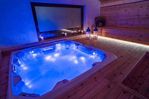 a jacuzzi tub in a room with a tv at Maison Rosset agriturismo, camere, APPARTAMENTI e spa in Valle d'Aosta in Nus