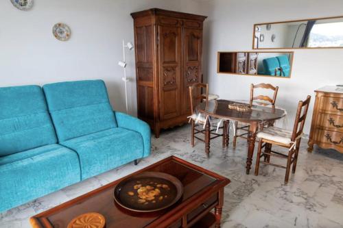 un salon avec un canapé bleu et une table dans l'établissement Lovely 48 m2 appt with sea view and swimming pool, à Antibes