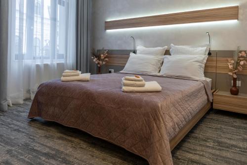 una camera da letto con un letto grande con asciugamani sopra di Olympic Boutique a Constanţa