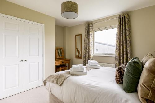 a bedroom with a white bed with a window at About Tern in Poole