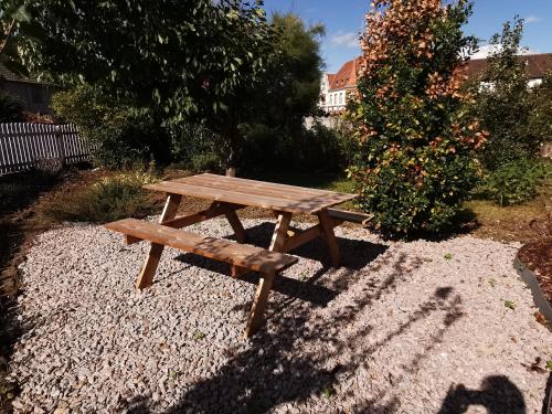 - une table de pique-nique en bois assise sur un sol en gravier dans l'établissement Appartement au calme RDC jardin, à Wasselonne