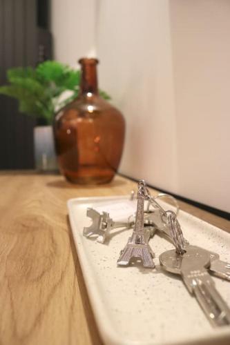 une paire de clés sur un plateau sur une table avec un vase dans l'établissement Cocon neuf - Coeur du 11e, à Paris