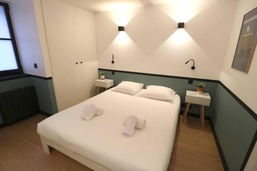 une chambre avec un lit blanc avec deux oreillers dans l'établissement Cocon neuf - Coeur du 11e, à Paris