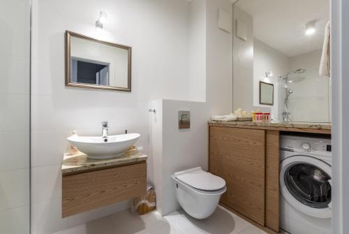 a bathroom with a sink and a washing machine at Baltic Sea Beachside Apartment in Gdańsk