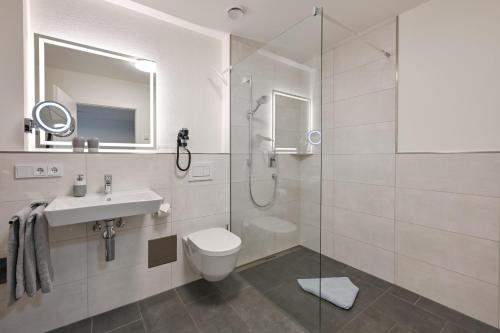 uma casa de banho com um chuveiro, um WC e um lavatório. em Ferienwohnungen Stock Ferienwohnung Nr 2 em Friedrichshafen