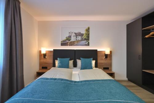 ein Schlafzimmer mit einem großen Bett mit blauen Kissen in der Unterkunft Ferienwohnungen Stock Ferienwohnung Nr 4 in Friedrichshafen