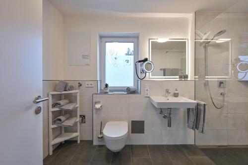 ein weißes Bad mit einem WC und einem Waschbecken in der Unterkunft Ferienwohnungen Stock Ferienwohnung Nr 4 in Friedrichshafen