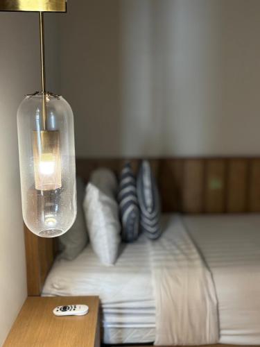 a bedroom with a bed with pillows and a lamp at 2BR Premium Suites Troika Kota Bharu By AGhome in Kota Bharu