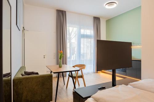 a living room with a bed and a tv at Nena Apartments Berlin Adlershof in Berlin