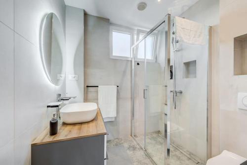 a white bathroom with a sink and a shower at Bells & Whistles, Comfortable Condo in Split