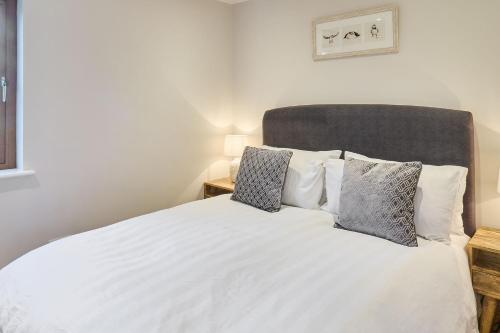 a bedroom with a white bed with two pillows at Host & Stay - Willow Barn in Aldington