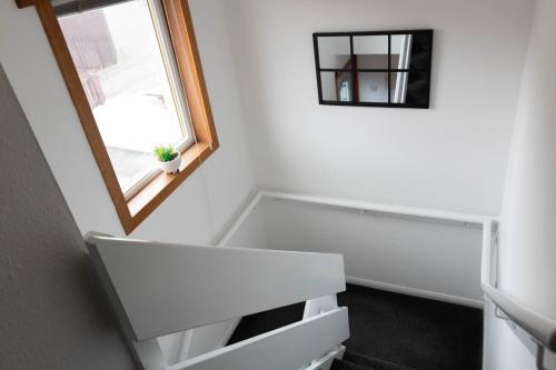 a white room with a mirror and a window at Dubbie House in Leven-Fife