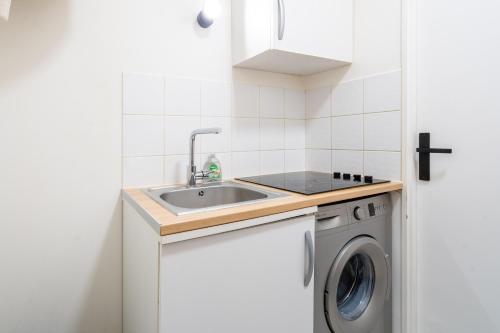 une petite cuisine avec un évier et une machine à laver dans l'établissement Studio confortable : Disney & Shopping, à Serris