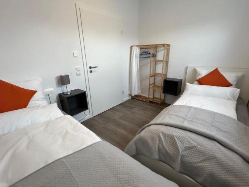 sypialnia z 2 łóżkami i lustrem w obiekcie "Golden Delicious" Neubau Barrierefrei Carport Terrasse Netflix Free WIFI w mieście Meppen