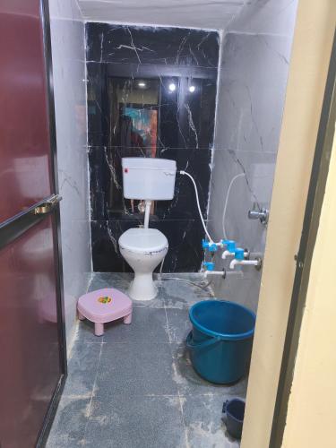 uma casa de banho com um WC e um balde em Anaadi home stay em Ujaim