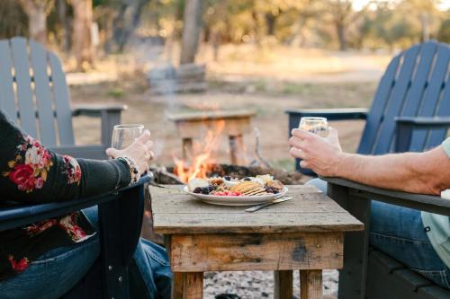 dos personas sentadas alrededor de una mesa con un plato de comida en Anderson Cottage at Wrenwood Ranch, King Bed, Walking Distance to the Winery, en Johnson City