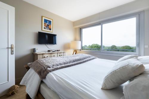 ラ・ボールにあるCASSIOPEE - Face MERのベッドと大きな窓のある寝室