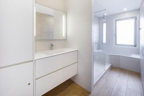 ラ・ボールにあるCASSIOPEE - Face MERの洗面台と鏡のある白いバスルーム