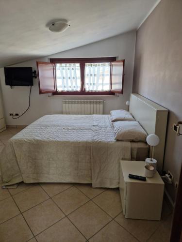 ein Schlafzimmer mit einem großen Bett und einem Fenster in der Unterkunft La Mansarda Di Cecco in Avezzano