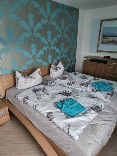 a large bed with two blue pillows on it at Ferienwohnung Metz in Waldberg