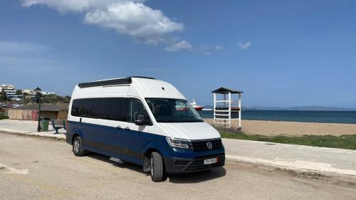 a blue and white van parked next to the beach at Reunion in Greece Campervan in Drafí