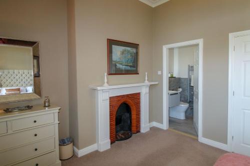 a living room with a fireplace and a bathroom at Geltsdale Wing, Wetheral in Wetheral