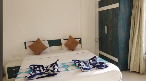 a bed with blue and white pillows on it at Sunrise Villa in Calangute