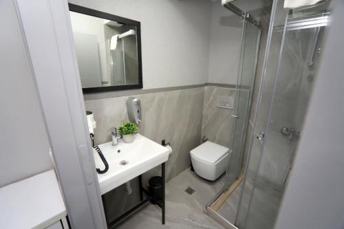 La salle de bains est pourvue de toilettes, d'un lavabo et d'une douche. dans l'établissement Arkem Hotel 1, à Istanbul