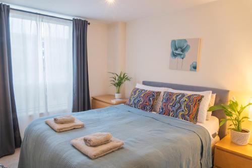 a bedroom with a bed with two towels on it at Stay in our Stylish Flat! & Parking & secure building & sleeps up to 4 in Birmingham