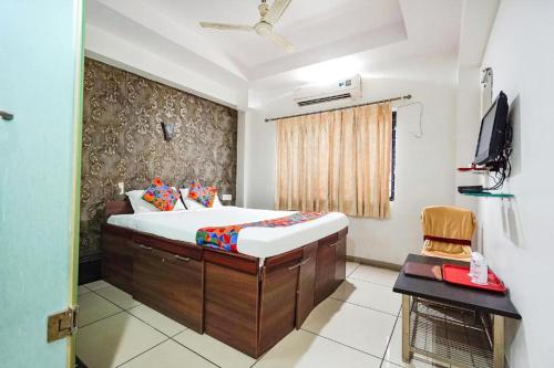 a bedroom with a bed and a television in it at Hotel JK Lions - Koradi, Nagpur in Nagpur