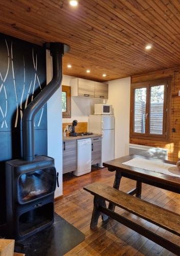 - une cuisine avec une cuisinière et une table dans une chambre dans l'établissement Chalet du Mont Ventoux - Rendez-vous en Provence, à Bédoin