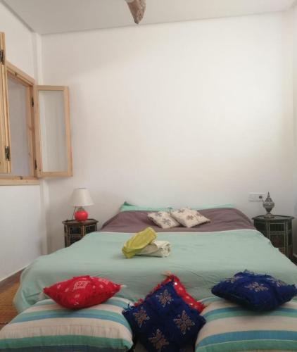 een slaapkamer met een bed met 2 kussens erop bij Jolie Appartement in Agadir