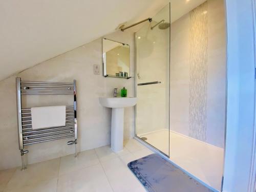 a bathroom with a shower and a sink and a toilet at Just £45pppn! Prime Comfort for Contractors with Spacious Parking, Plush Beds, Top-notch Amenities, Flexible Stays & Lightning-Fast Internet in Woking